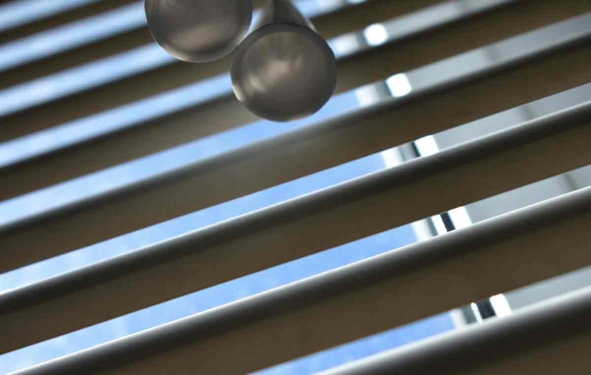 White window blinds with cord covering a half circle window near Chicagoland, IL.